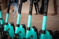 A fleet of dockless electric scooters for rent, lined up on a European city street, offering an eco-friendly, convenient & modern