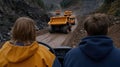 A fleet of large yellow mining trucks drives along a dirt road in a unique open-pit mine, featuring a visually striking Royalty Free Stock Photo