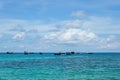 Fleet of small vessels moored in the tranquil blue waters of a picturesque shoreline