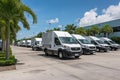 Fleet of White Commercial Vehicles in a Vibrant Industrial Setting