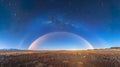 The fleeting sight of a moonbow forms in the night sky, casting its ethereal glow over the la Royalty Free Stock Photo