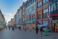 Passers-by stroll between stores in the busy Holm shopping street in Flensburg, Germany