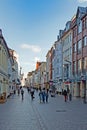 Passers-by stroll between stores in the busy Holm shopping street in Flensburg, Germany