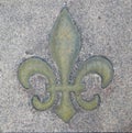 Fleur-de-lis in terrazo sidewalk is old Royalty Free Stock Photo