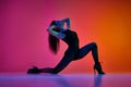 Flexibility and passion. Young woman dancing high heel, contemp dance over gradient pink red studio background in neon Royalty Free Stock Photo