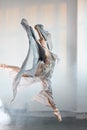 Flexible ballet dancer stretching in the dark lighted studio