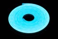 Flexible blue led tape neon flex in roll on black background Royalty Free Stock Photo