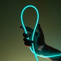 Flexible blue led tape neon in hand on black background Royalty Free Stock Photo