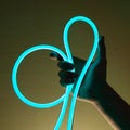 Flexible blue led tape neon in hand on black background Royalty Free Stock Photo