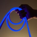 Flexible blue led tape neon in hand on black background Royalty Free Stock Photo