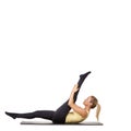 Flexible fitness. A fit young woman stretching out her legs on an exercise mat - isolated. Royalty Free Stock Photo