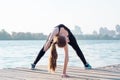 Flexible fitness woman stretches at bridge yoga exercise outdoor