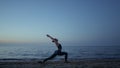 Flexible girl doing warrior asana raising hands to sky. Woman standing yoga pose Royalty Free Stock Photo