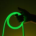 Flexible green led tape neon in hand on black background Royalty Free Stock Photo