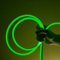 Flexible green led tape neon in hand on black background Royalty Free Stock Photo