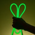 Flexible green led tape neon in hand on black background Royalty Free Stock Photo