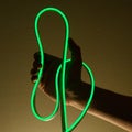 Flexible green led tape neon in hand on black background Royalty Free Stock Photo