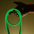 Flexible green led tape neon in hand on black background Royalty Free Stock Photo