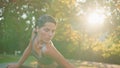 Flexible lady bending body at sun park closeup. Sportswoman stretching shoulders