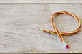 Flexible pencil on old wooden table . Bending pencil