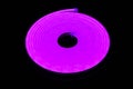 Flexible purple led tape neon flex in roll on black background Royalty Free Stock Photo