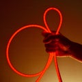 Flexible red led tape neon in hand on black background Royalty Free Stock Photo