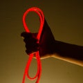 Flexible red led tape neon in hand on black background Royalty Free Stock Photo