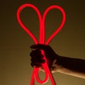 Flexible red led tape neon in hand on black background Royalty Free Stock Photo