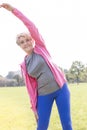 Flexible senior woman doing workout in park