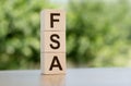 Flexible spending account FSA written on a wooden cubes on blurred nature background Royalty Free Stock Photo