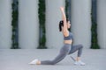 Flexible woman doing yoga on a concrete paving, doing forward bends