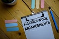 Flexible Work Arrangements write on a paperwork isolated on wooden background Royalty Free Stock Photo