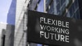 The Flexible Working Future on a black city-center sign in front of a modern office building