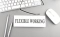 FLEXIBLE WORKING text on paper with keyboard on grey background