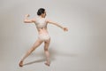 Flexible young ballet dancer performing near the white wall