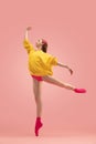 Flexible young beautiful girl, female ballet dancer training isolated over pink background. Royalty Free Stock Photo