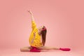 Flexible young beautiful girl, female ballet dancer training isolated over pink background. Royalty Free Stock Photo