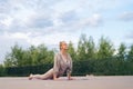 Flexible young woman with sporty body doing yoga exercise Upward Wheel or Bow Pose lying on yoga mat in city park. Y Royalty Free Stock Photo