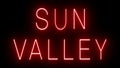 Glowing and blinking red retro neon sign for SUN VALLEY