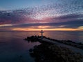 A flight around a Christian Holy cross early in the morning at sunrise. The large cross stands on the edge of a