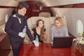 Flight attendant gives water to first class passengers inside airplane. Royalty Free Stock Photo