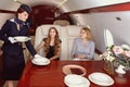 The flight attendant serves the passengers of the business jet. Royalty Free Stock Photo