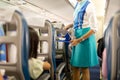 Flight attendant serving drinks to passengers on board. Royalty Free Stock Photo