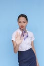 A flight attendant telling a passenger to stop. A stewardess with her right palm facing the camera. Not allowed