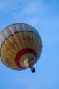 Flying balloon with passengers in a basket against the blue sky at the festival of Aeronautics summer evening in Pereslavl-Zalessk