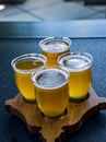 A flight of beers on a wooden paddle