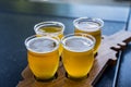 A flight of beers on a wooden paddle