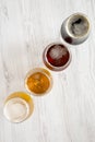 Flight of beers on a white wooden background, top view. Overhead, from above