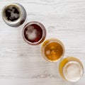 Flight of beers on a white wooden table, top view. Overhead, from above