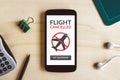 Flight cancelled concept on mobile phone over wooden desk